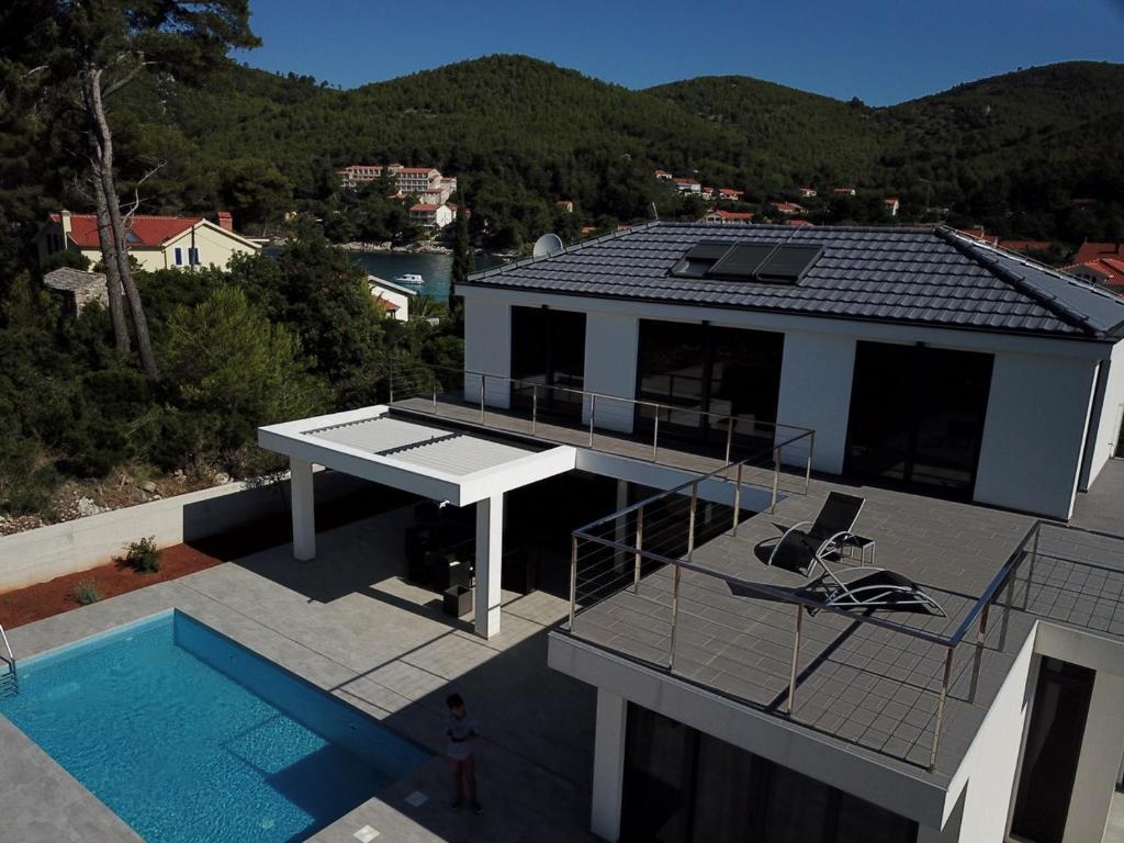 a house with a swimming pool and a roof at Seaside villa at Prizba in Prizba