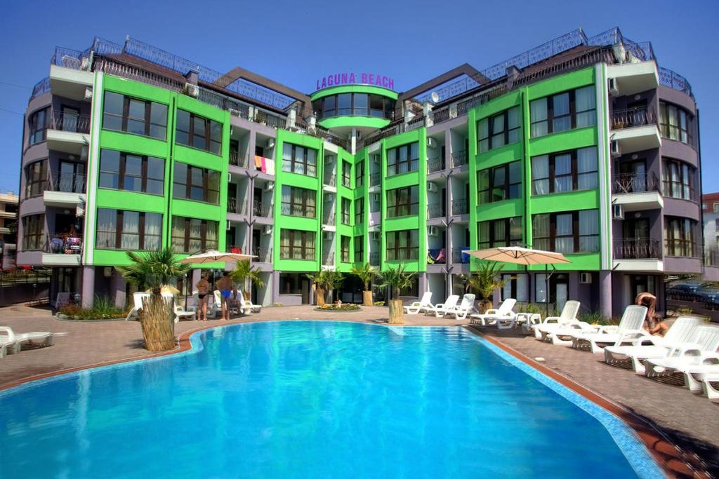 a hotel with a swimming pool in front of two buildings at Laguna Beach Hotel in Ravda