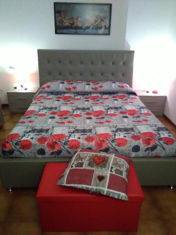 łóżko z kołdrą i czerwoną otomaną w sypialni w obiekcie House Rose w mieście Rose