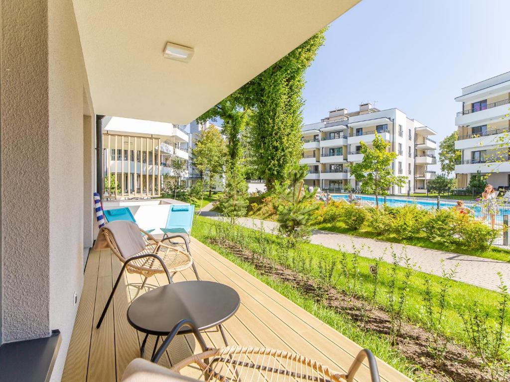 a balcony with chairs and a view of a park at Rezydencja Ustronie Morskie 5/5 in Ustronie Morskie