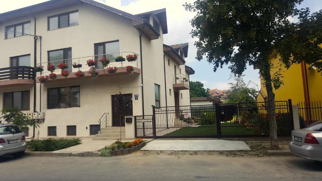 Casa blanca con flores en el balcón en Villa Sanitas, en Techirghiol