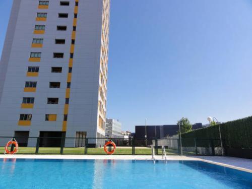 a large swimming pool in front of a tall building at JA Suites Madrid in Madrid
