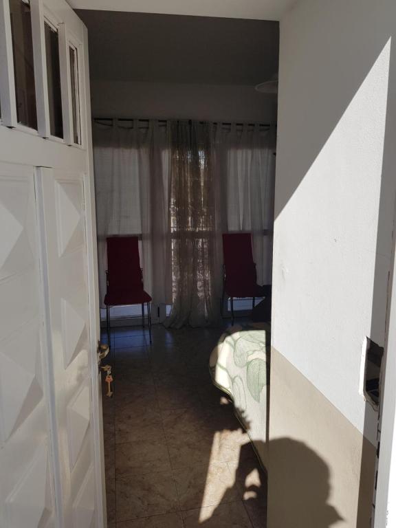 Habitación con cama, 2 sillas y ventana en Alojamiento Cba Observatorio en Córdoba