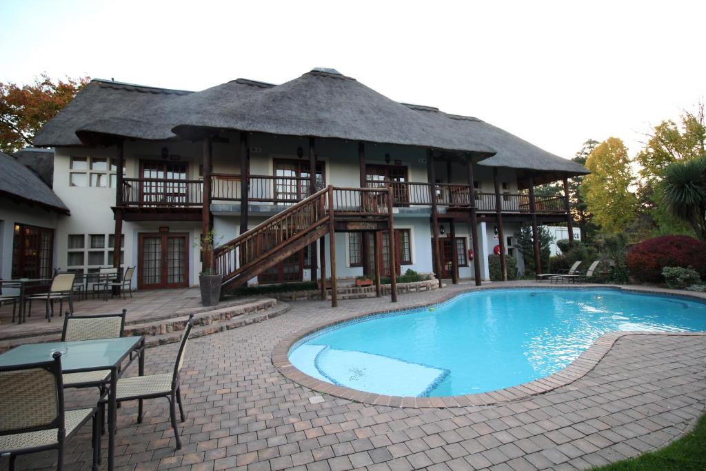 a resort with a swimming pool in front of a building at Oak Park and Conference Centre in Kokstad