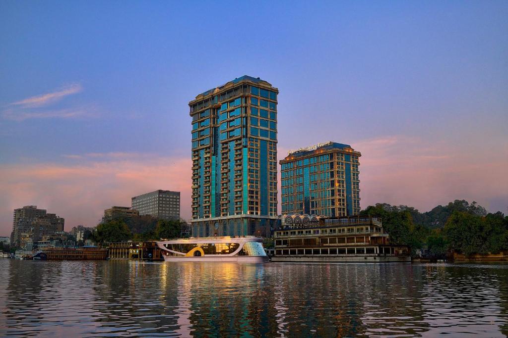 two tall buildings next to a large body of water at Four Seasons Cairo At The First Residence in Cairo