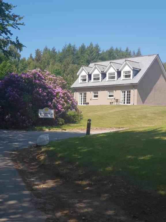 a large house with a flowering bush in front of it at Inchmarlo villa27 in Banchory