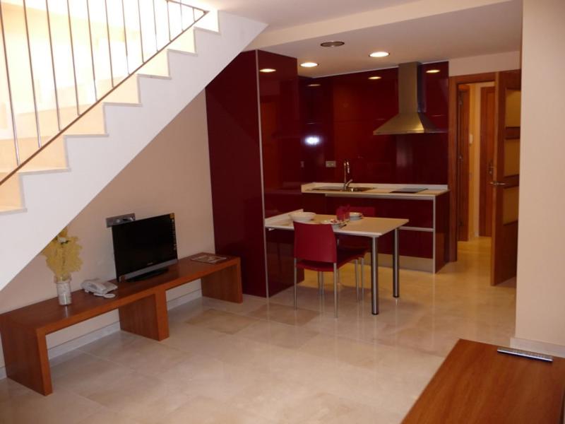 een woonkamer met een keuken, een eettafel en een trap bij Hotel Verti in Corró de Vall