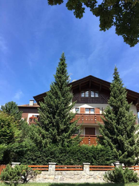 un edificio con dos pinos delante en Villa Fiordaliso, en Bormio