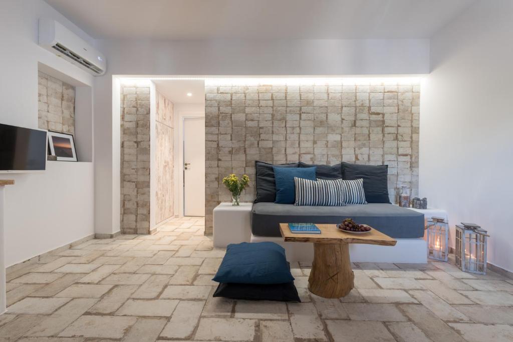 un soggiorno con letto blu e tavolo di Elia Residences Santorini a Karterados