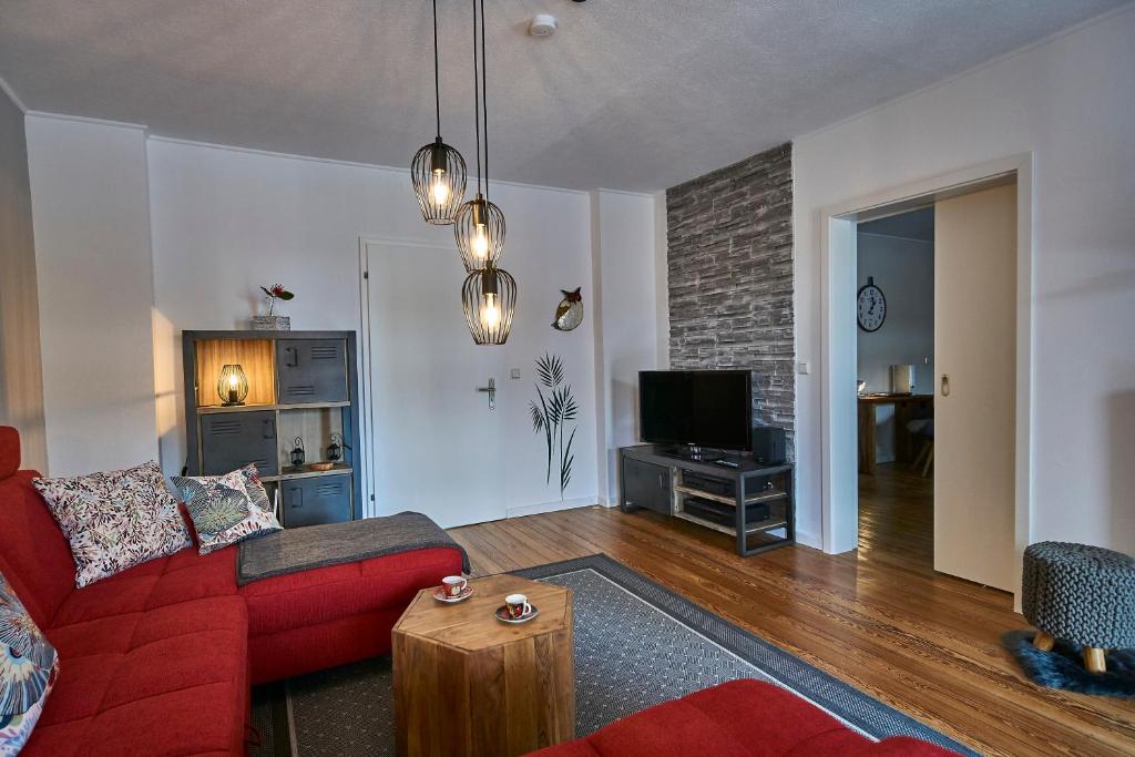 a living room with a red couch and a tv at Ferienwohnung Atrium in Niederlinxweiler