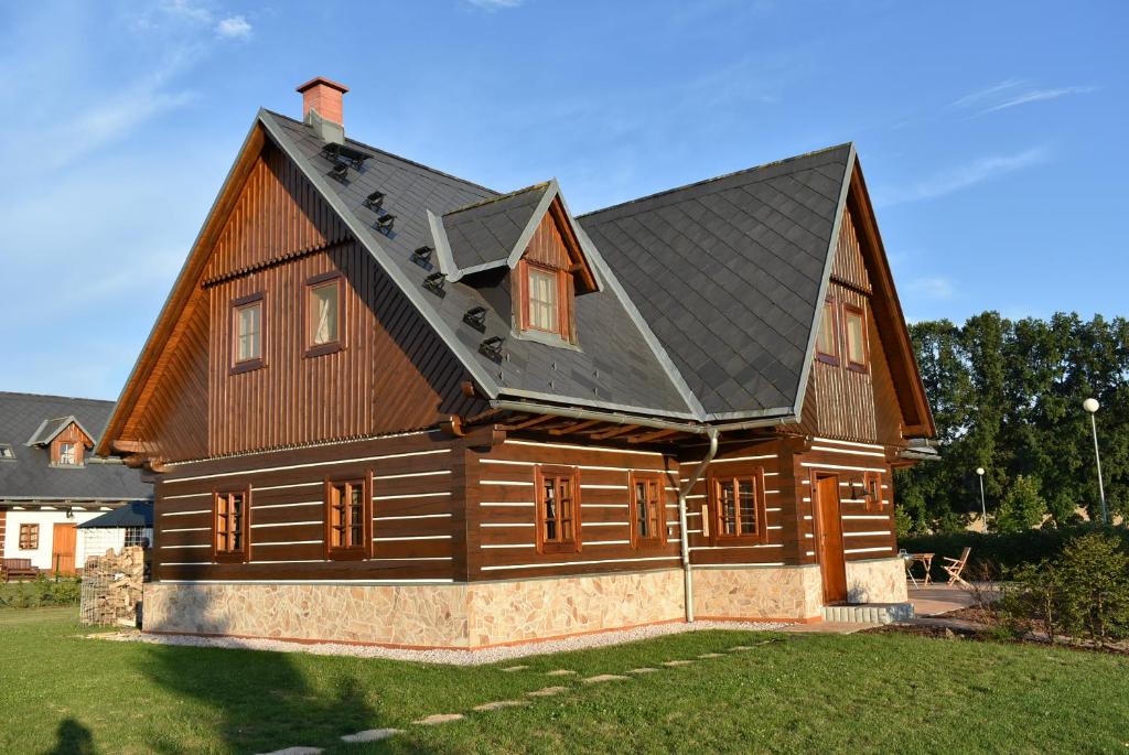 a large wooden house with a black roof at Villa Harta in Vrchlabí