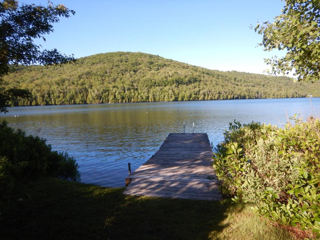 a dock on a lake with a mountain in the background at Chalets Laurentides Mont-Tremblant in Mont-Tremblant