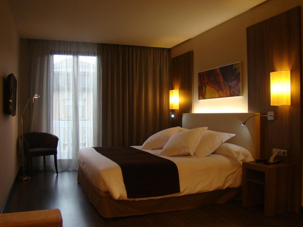 Habitación de hotel con cama grande y ventana en Hotel Aroi Ponferrada en Ponferrada