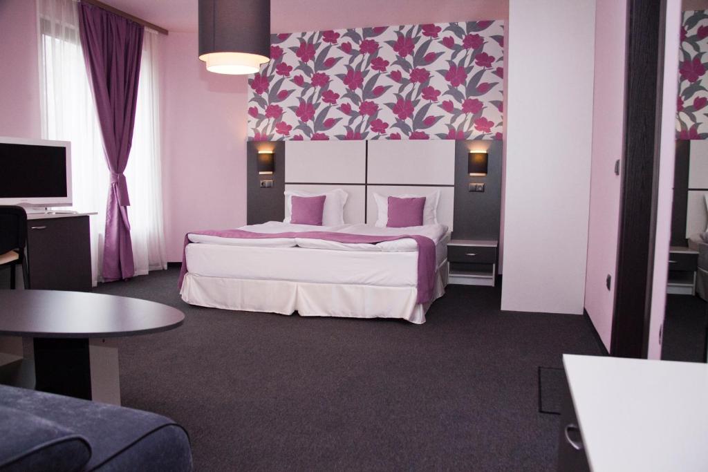 Un dormitorio con una cama grande y una pared rosa en Gran Via en Burgas