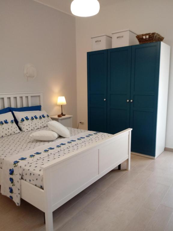 a bedroom with a white bed and blue cabinets at La Casa sul Mare - Veliero in Balestrate