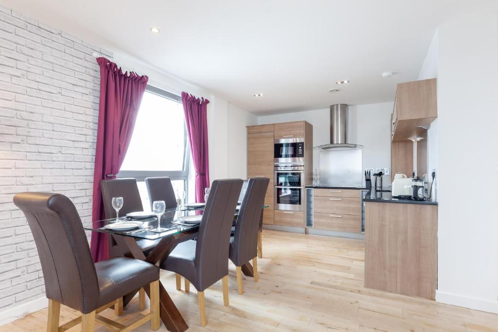 cocina y comedor con mesa y sillas en Stylish Penthouse Suite, en Edimburgo