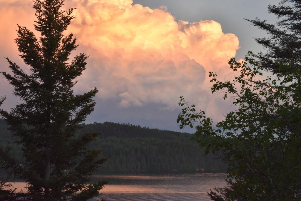 eine Wolke am Himmel über einem Wasserkörper in der Unterkunft Le Gite de la Renarde in Saint-Félix-d'Otis