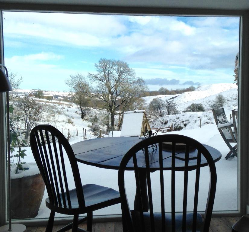 a table and chairs on a porch in the snow at The End Place in Pateley Bridge