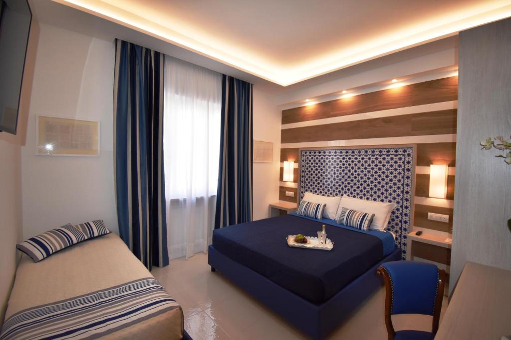 Postel nebo postele na pokoji v ubytování Melody Sorrento Suites