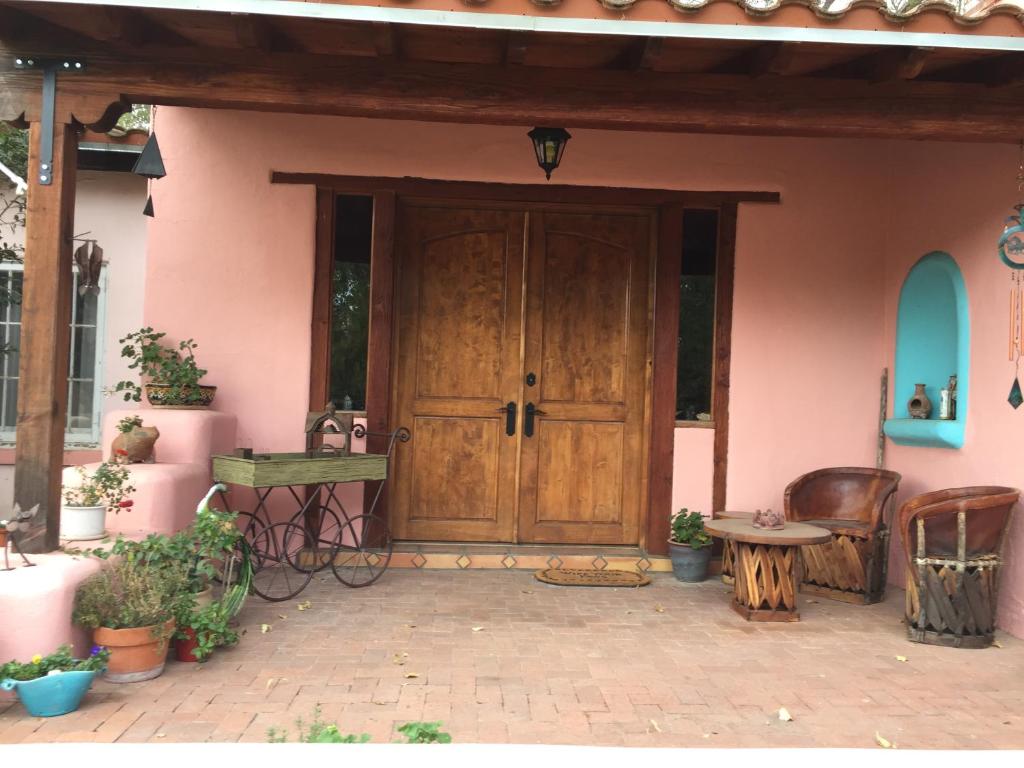 a pink house with a wooden door and a patio at Casa Paloma B&B in Tubac