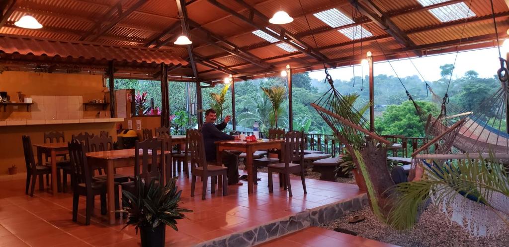 um homem sentado numa mesa num restaurante em Cabinas Pura Vida B&B Tour Operator em Drake