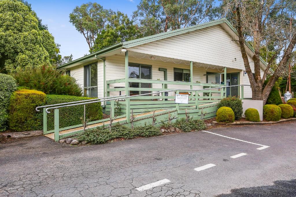 una casa con una valla verde delante de ella en Enclave at Healesville Holiday Park, en Healesville