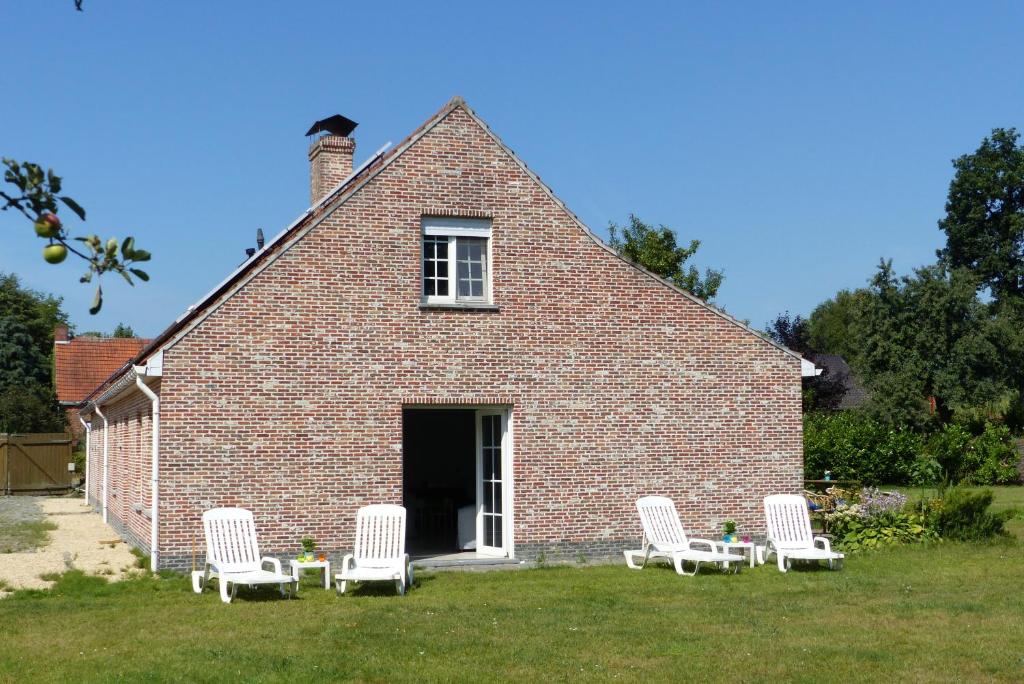 a group of white chairs in front of a brick house at Kalmthoutse Hoeve in Kalmthout