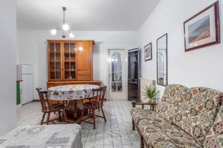 sala de estar con mesa y sofá en casetta cassia roma, en Isola Farnese