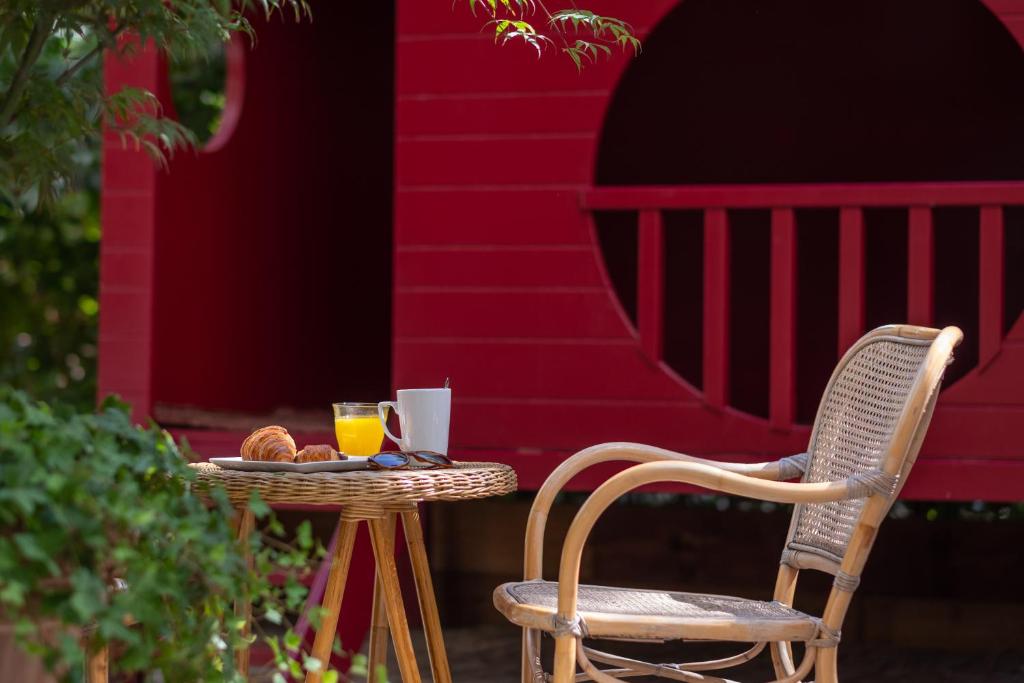 a table with two chairs and a glass of orange juice at ibis Styles Paris Nation Cours de Vincennes in Paris