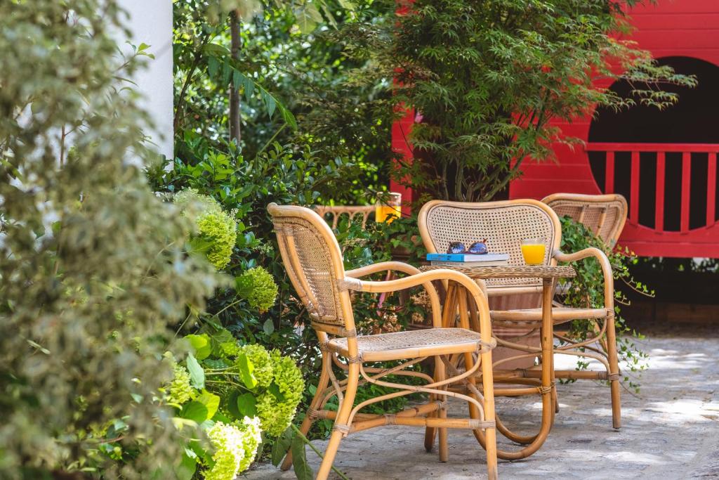 three wicker chairs and a table in a garden at ibis Styles Paris Nation Cours de Vincennes in Paris