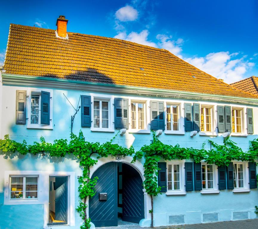 a large white house with a blue garage at Romantische Ferienwohnungen Deidesheim in Deidesheim