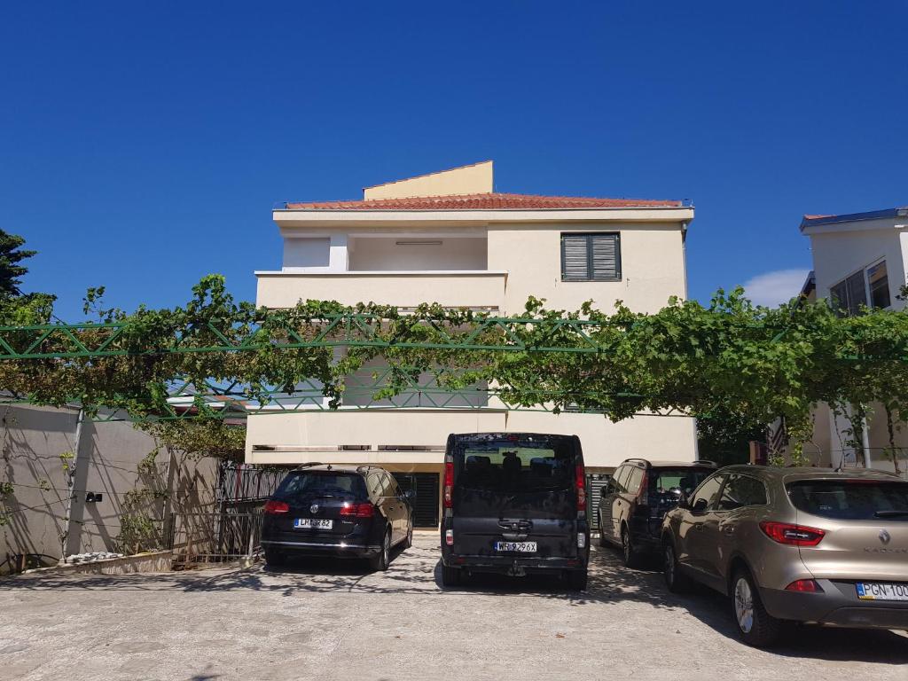 two cars parked in a parking lot in front of a building at Apartment Lavanda in Starigrad