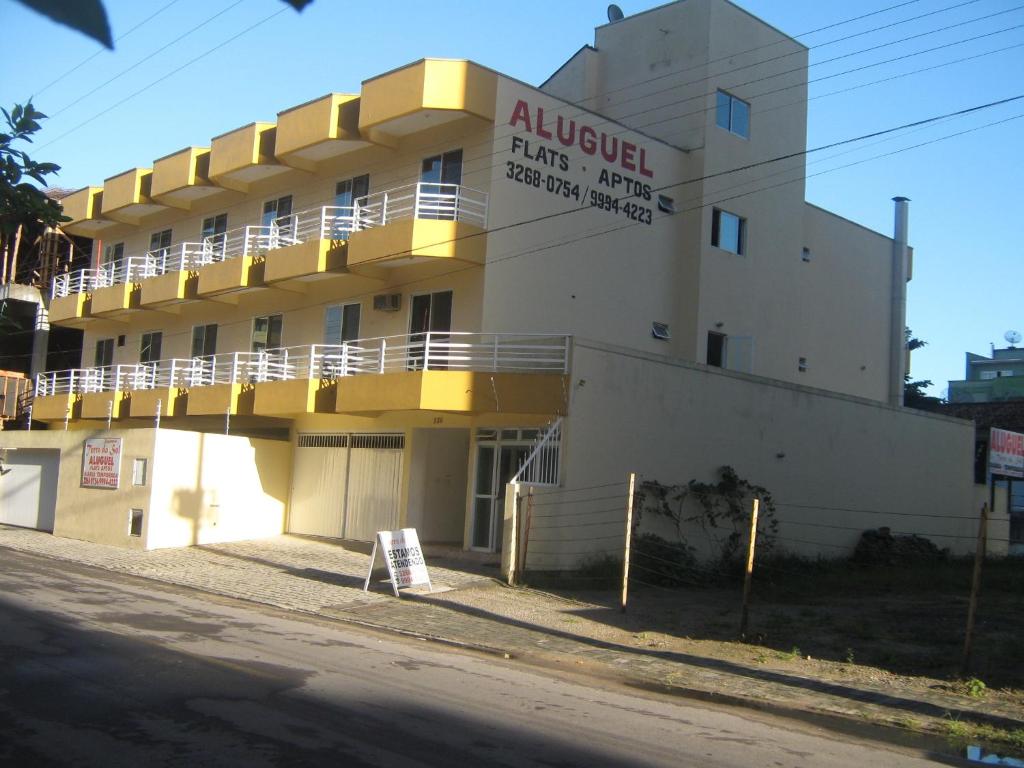a building with a sign on the side of it at Pousada Terra do Sol in Itapema