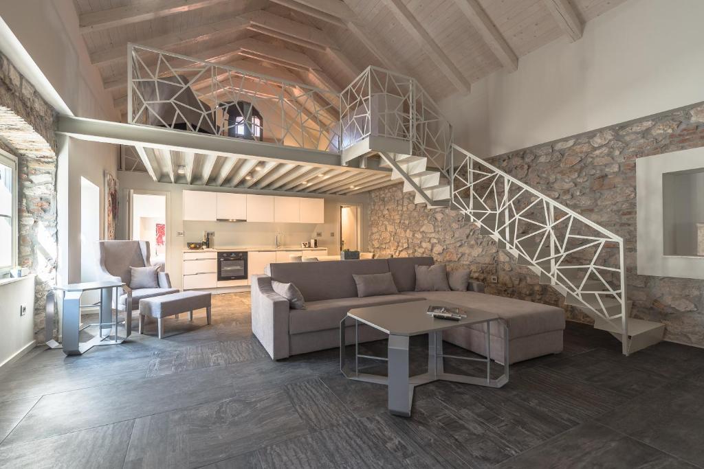 a living room with a couch and a staircase at Alma Lofts in Zadar