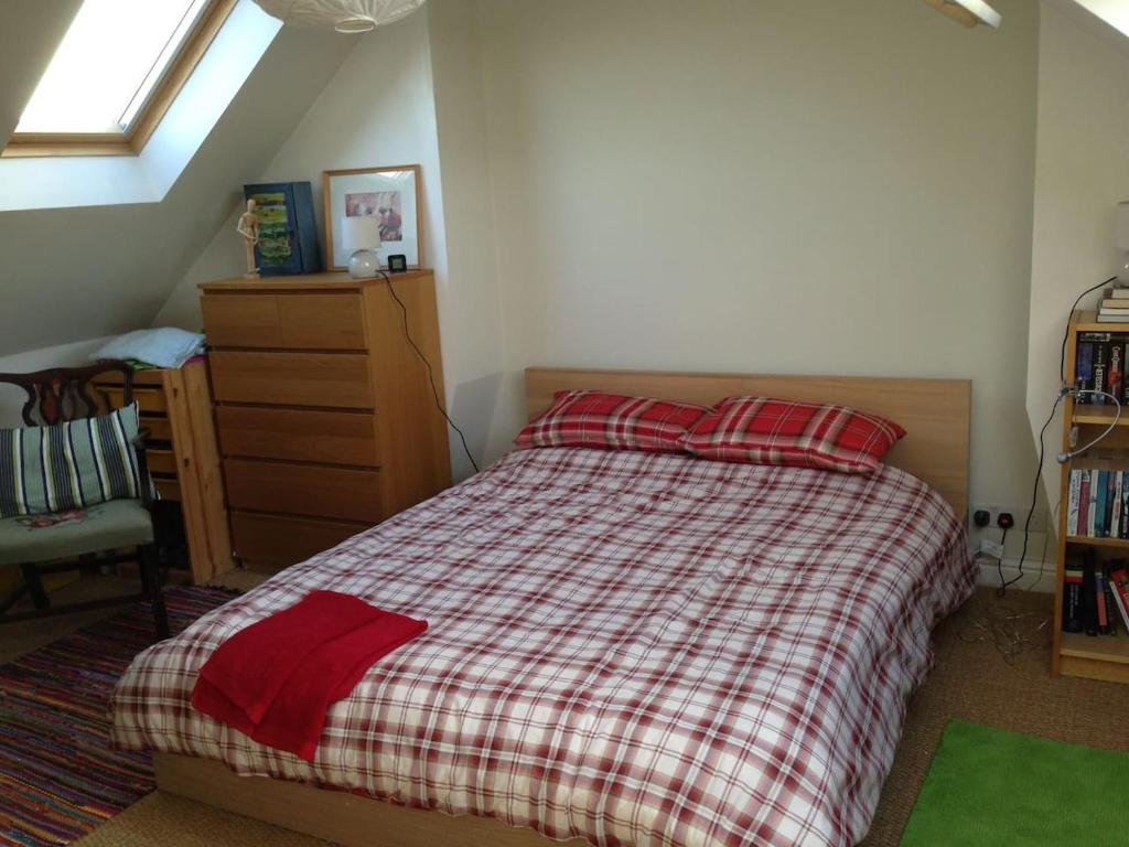 a bedroom with a bed with red pillows and a window at Fishponds Retreat Homestay in Bristol