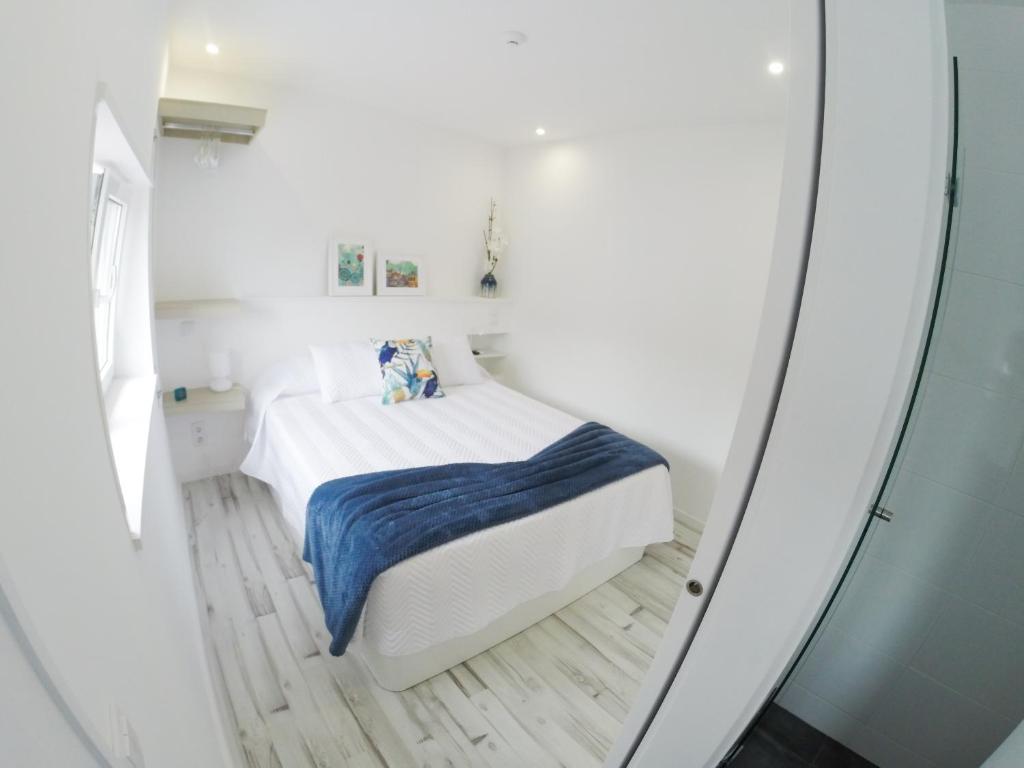 a small white bedroom with a bed in a room at Casa d'Avó in Porto