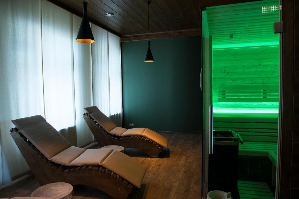 two chairs in a waiting room with green lighting at Hotel Na Baste in Jablonec nad Nisou
