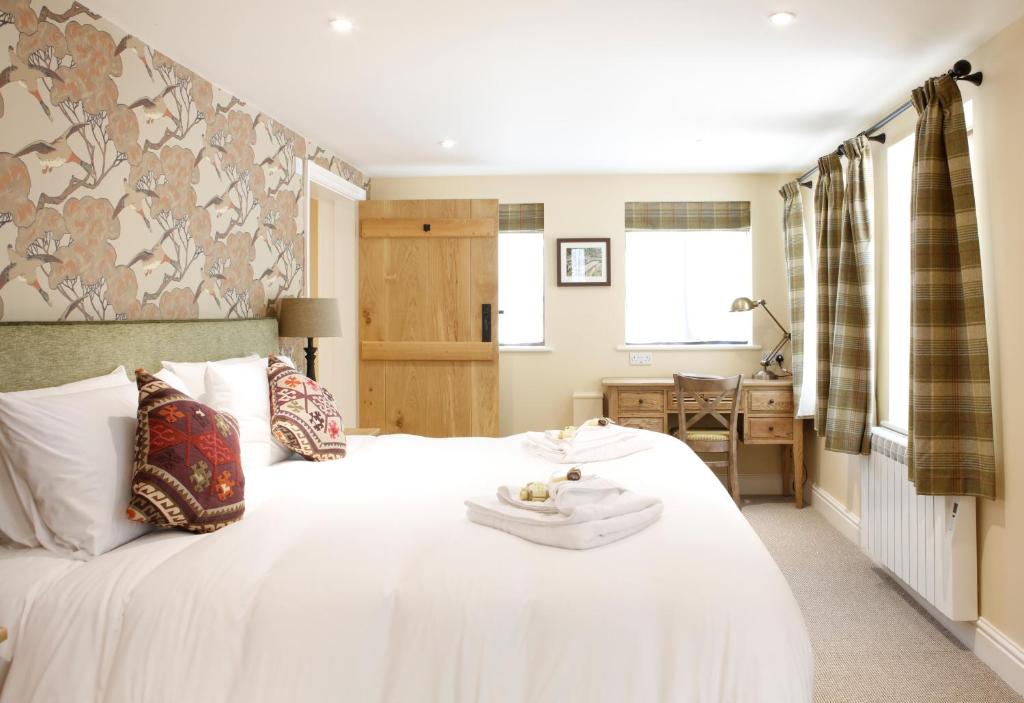 a bedroom with a white bed with a tray on it at Bartons Mill Pub and Dining in Basingstoke