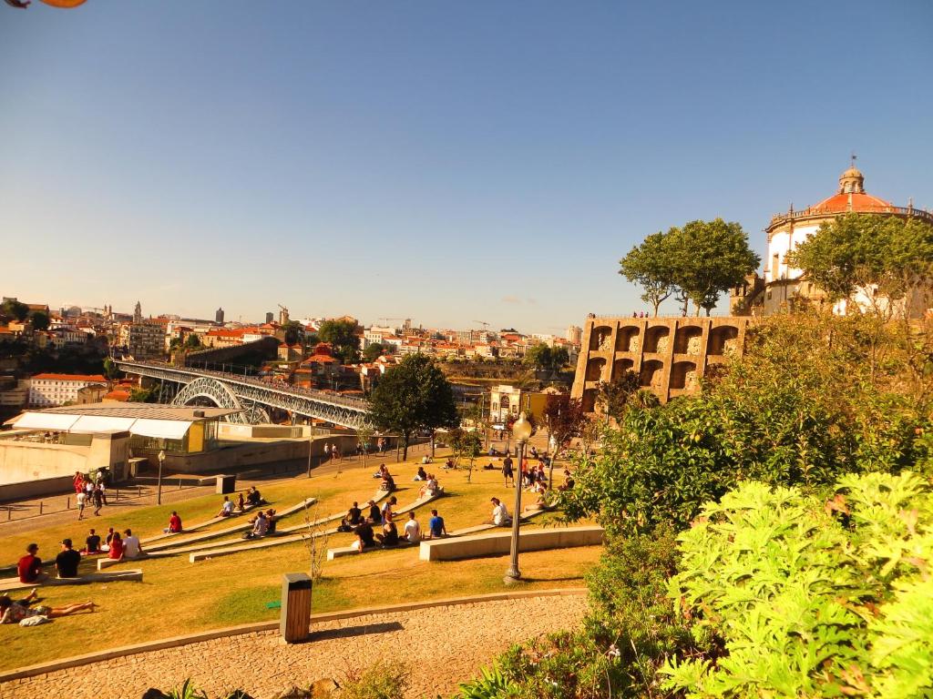a group of people sitting on the grass in a park at House T3 in Vila Nova de Gaia
