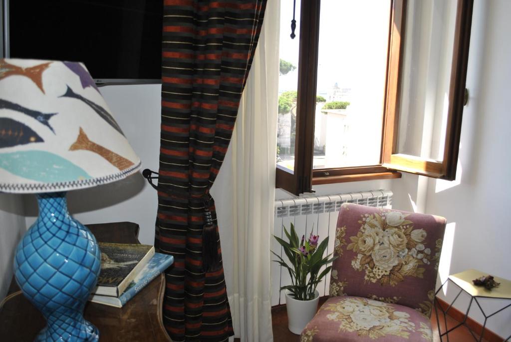 a living room with a chair and a window at BUBA BnB SUPERIOR in Anzio