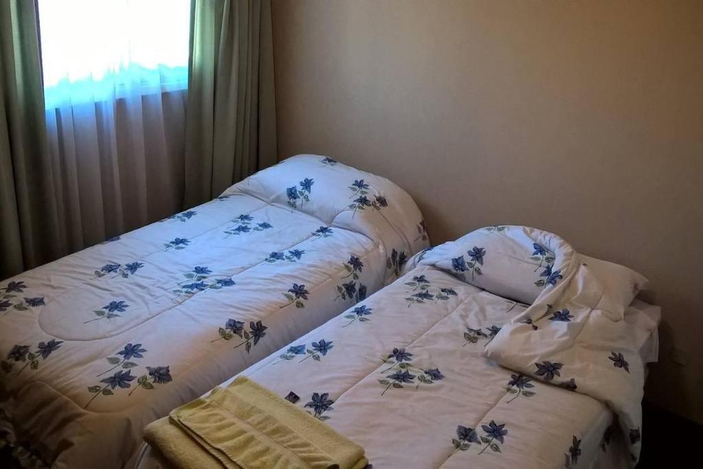 1 dormitorio con 1 cama con edredón de flores en Depto frente a plaza independencia en Mendoza