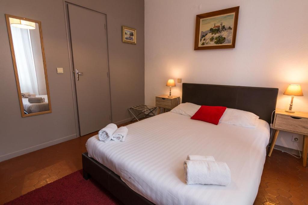 a bedroom with a large bed with towels on it at Ma Petite Auberge in Castellane