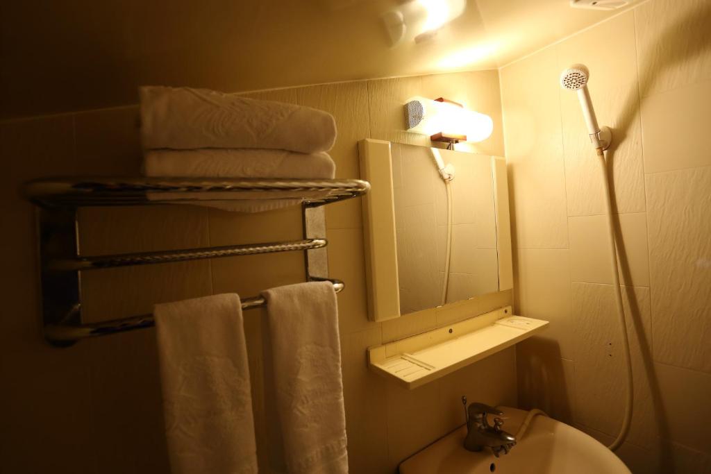 a bathroom with a sink and a mirror and towels at Cingjing Hanging Garden &amp; Resort in Ren&#39;ai