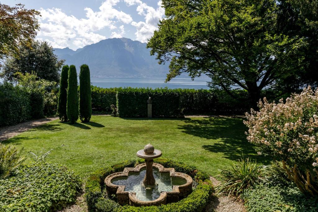 a garden with a fountain in the middle of a yard at Villa Kruger on the Lake in Montreux