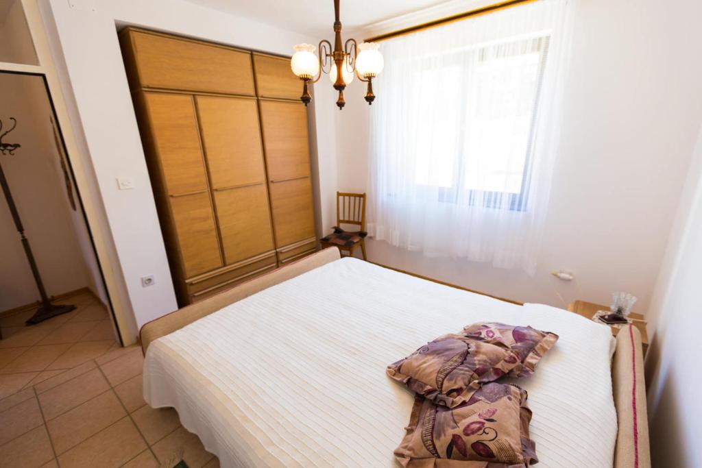 ein Schlafzimmer mit einem Bett in einem Zimmer mit einem Fenster in der Unterkunft Adelia in Mali Lošinj