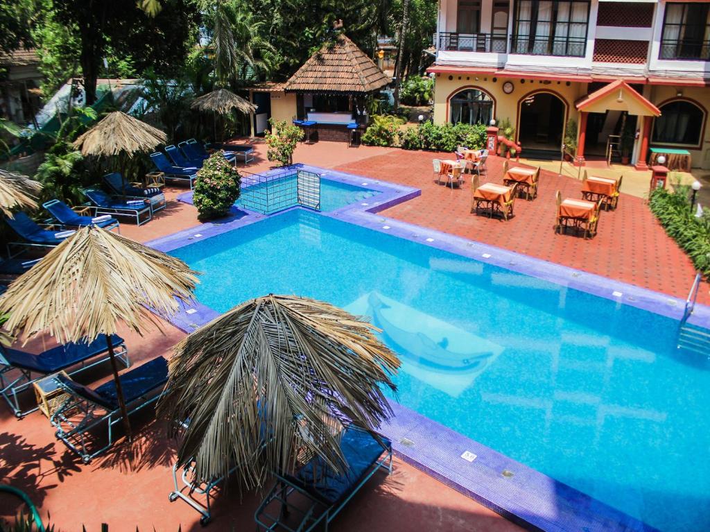an overhead view of a swimming pool with chairs and umbrellas at The Horizon in Calangute