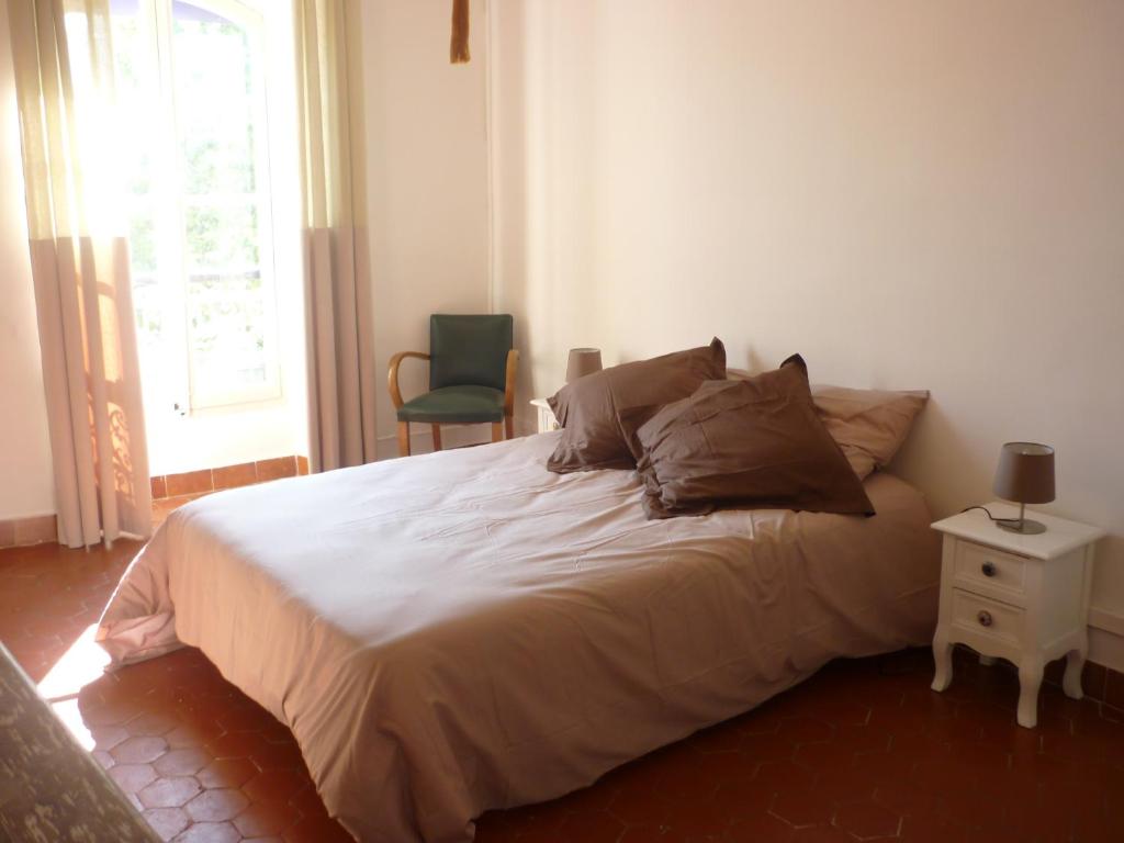 ein Schlafzimmer mit einem Bett, einem Stuhl und einem Fenster in der Unterkunft Chez Albert et Karine in Sauve