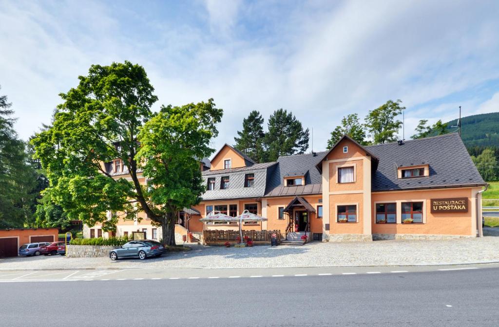 a large house with a car parked in front of it at Hotel Stara Posta in Filipovice