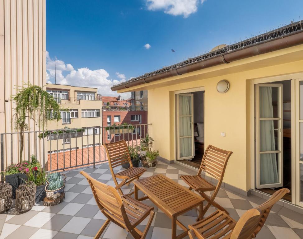 Un patio con sillas y una mesa en el balcón. en 4 Elements Apartments by Adrez, en Praga