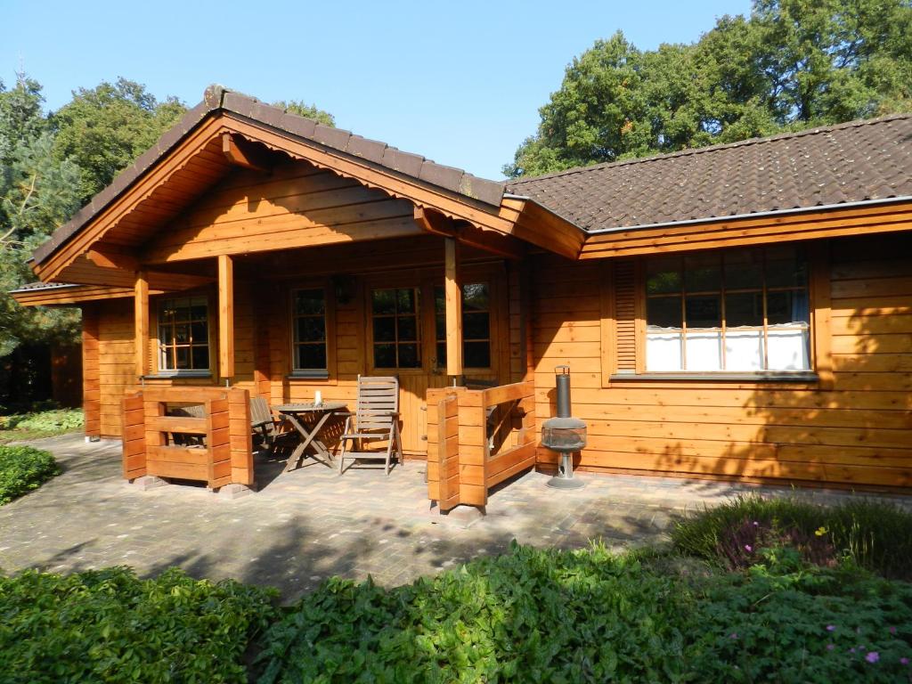a log cabin with a patio and a table at Chalet Nieuw Beusink in Winterswijk